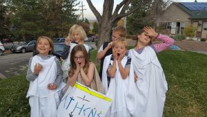 students dressed in Greek chitons gesturing dramatically