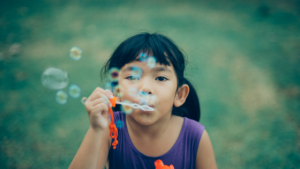 girl blowing bubbles