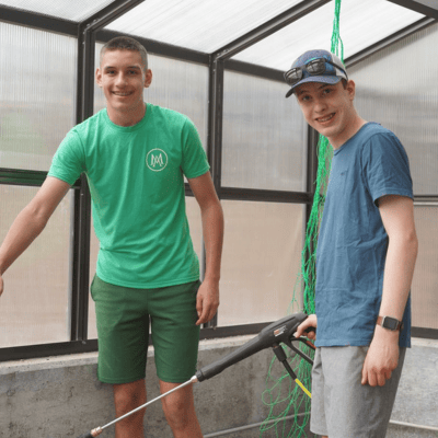 two boys working in a greenhouse